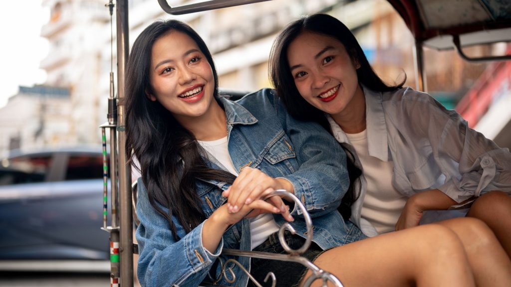 Two women smiling and enjoying a day out in the city, representing renewed confidence and freedom after successful urine incontinence treatment in Singapore.