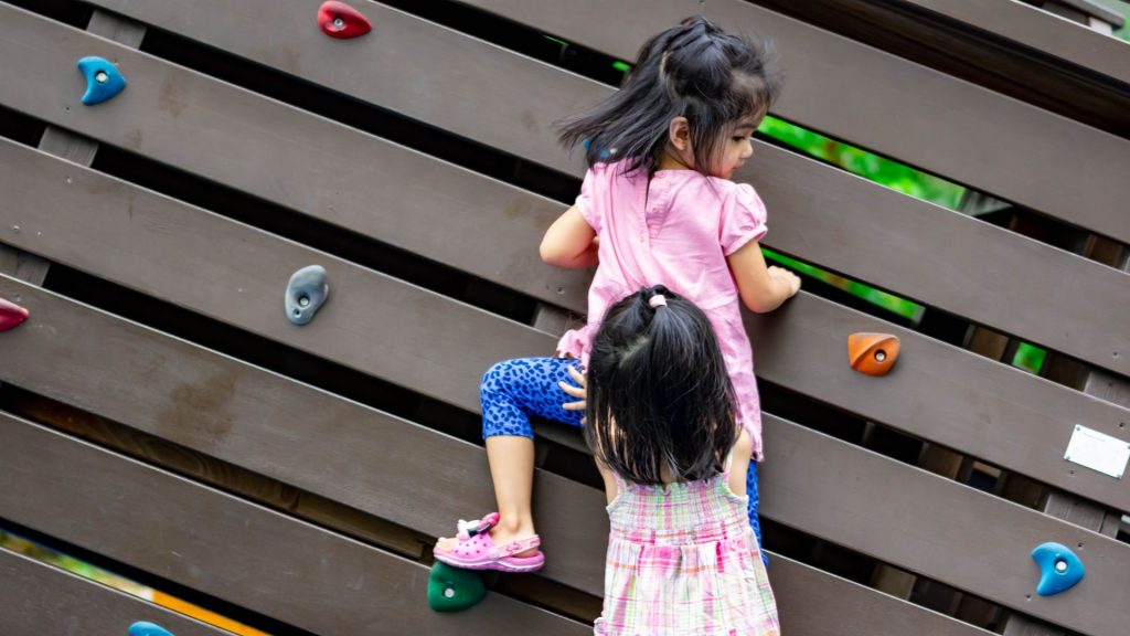 Children climbing at playground, building strength and coordination to help improve intoeing naturally.
