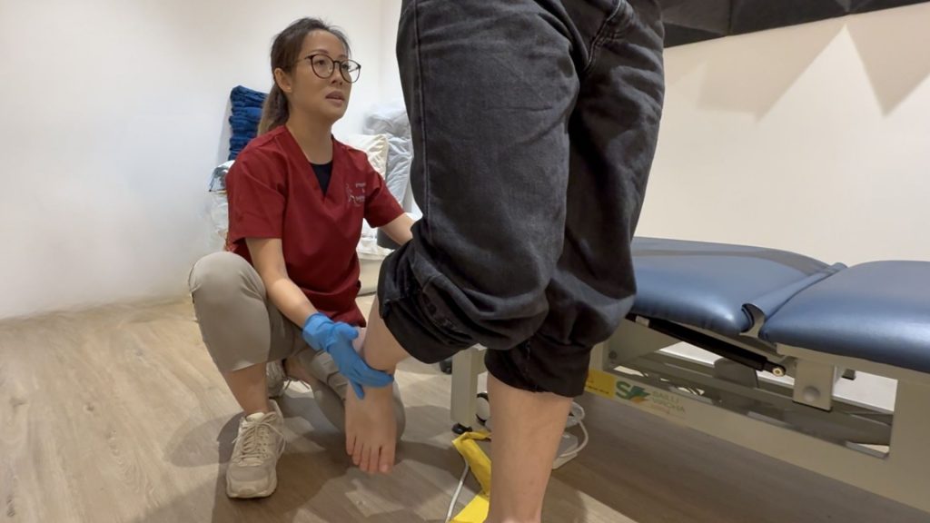 Podiatrist assessing a patient’s ankle and foot posture during a clinical examination.