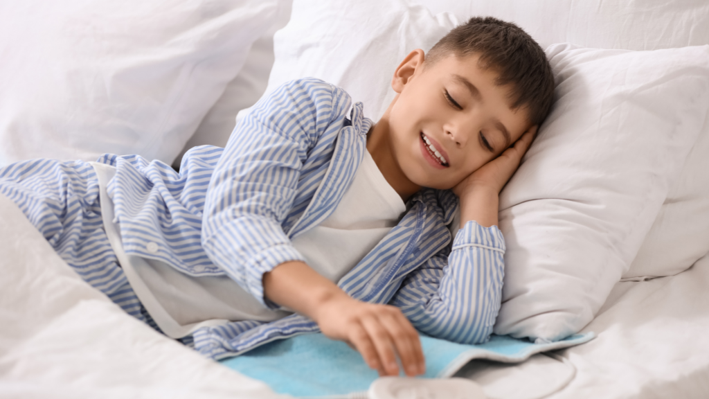 Young child resting comfortably in bed, highlighting the importance of adequate sleep and recovery in managing pain and fatigue in children with joint hypermobility.